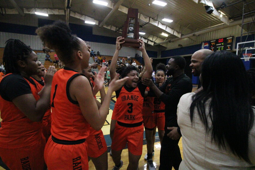 Orange Park guard Mariah Young holds up district 3-5A championship trophy after the Raiders defeated Ridgeview 44-38 Saturday afternoon.