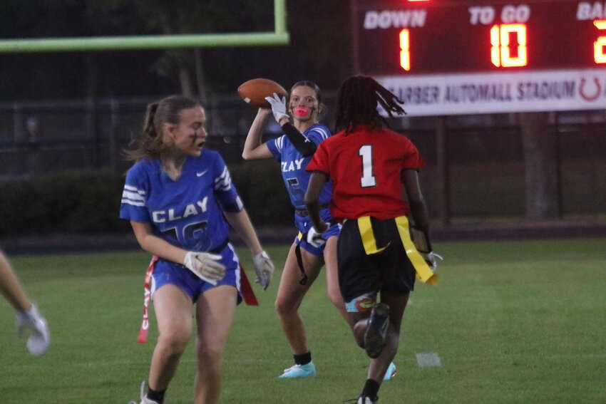 Clay QB Cora Parker hurries to let go with pass with Middleburg rusher Haven Lang in her face. Clay won 18-6.
