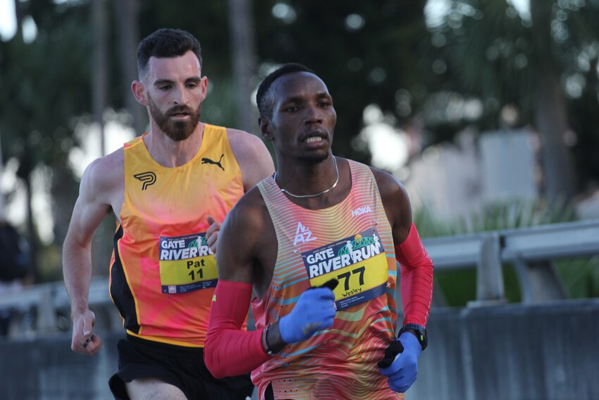 Gate River Run 15K record setting champion Wesley Kiptoo, No. 77, runs with Pat Tierney of Pennsylvania in early miles of Gate River Run 15K on Saturday. Kiptoo won with 42:09 time to beat American Todd Williams record of 42:20.