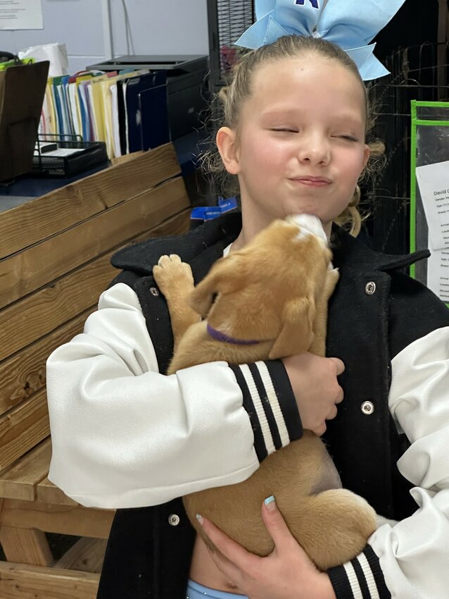 Leighton gets a kiss from Winnie, one of the eight puppies that came from Bradford County.