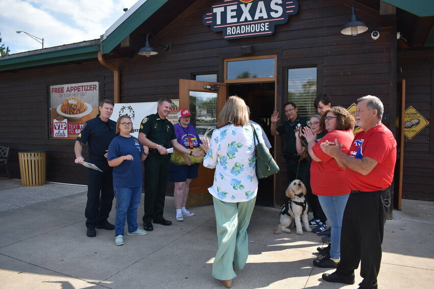 A group of Clay County Sheriff's Office deputies, Special Olympics athletes, volunteers and Orange Park Police officers welcome customers to the Texas Roadhouse during last year's Tip-A-Cop.