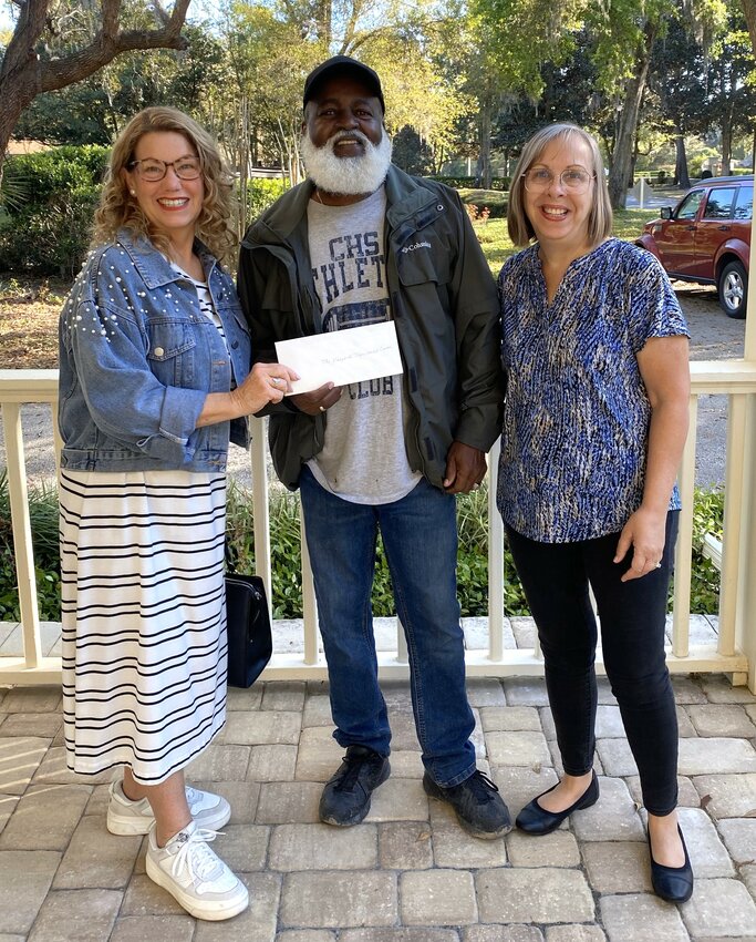 Magnolia Point Women's Club president Donna Habing and treasurer Linda Werring present a check to John Sanders of the Vineyard Transition Center, one of the organizations the Club recognized.