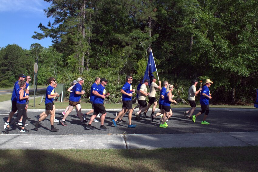 The first wave of law enforcement personnel turns the final corner and heads toward the finish line in the Plantation Sports Complex.