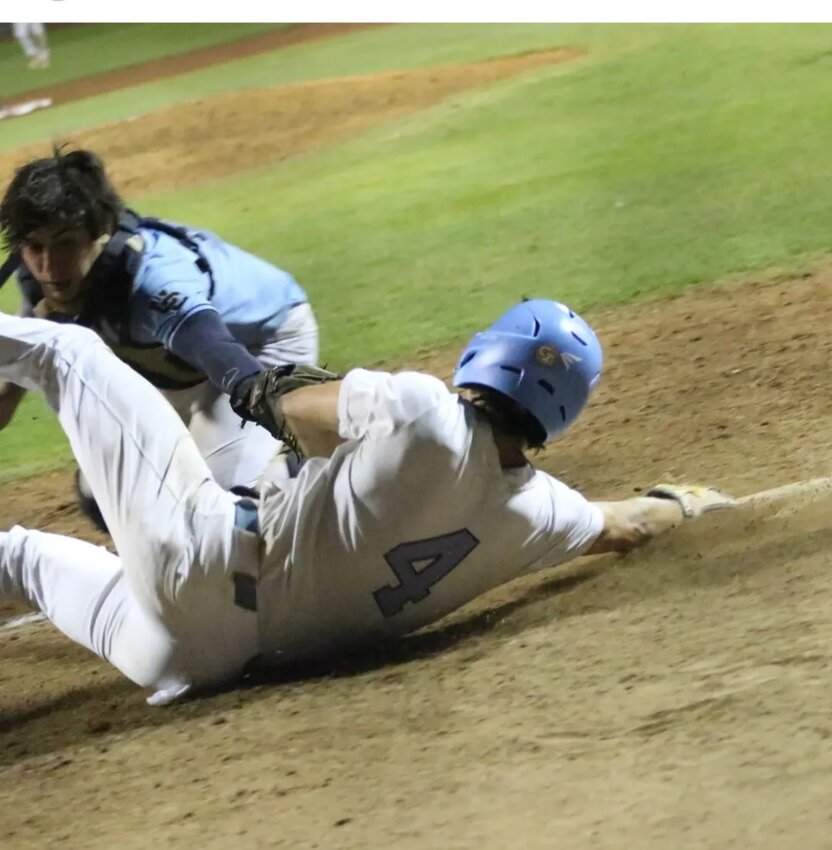 St. Johns baserunner Preston Cole slides just out of reach of University of Christian catcher's glove to score gamewinner in 8-7 region championship win over University Christian.