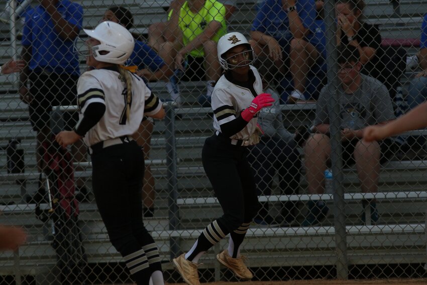 Oakleaf High's Ava Tolbert spins around teammate Jaydyn Beall after scoring winning run in Knights 2-1 region quarterfinal win over BartramTrail on Thursday.