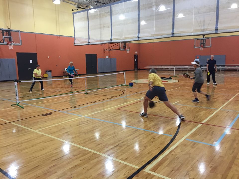 Fletcher Turner, far right, is among the many devoted pickleball players who frequent the Barco-Newton YMCA on Fleming Island. Here, he watches four friends take part in a game of pickleball, which is one of the fastest-growing sports in the U.S.