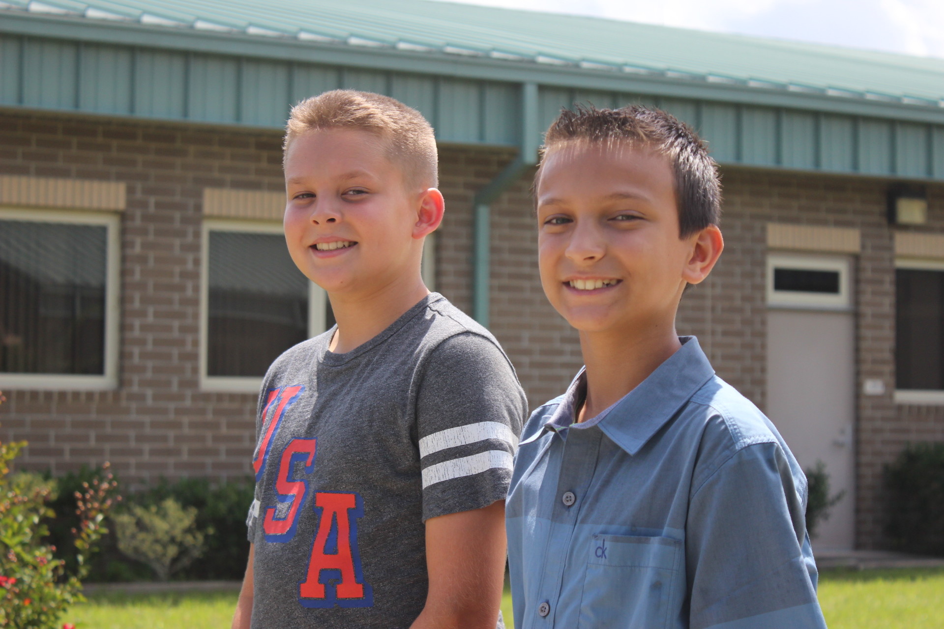 From left, Nate Helmuth and Isaac Davis, both 11, stand at the same pole they folded the United States flag at during an Aug. 17 rainstorm at Coppergate Elementary.
