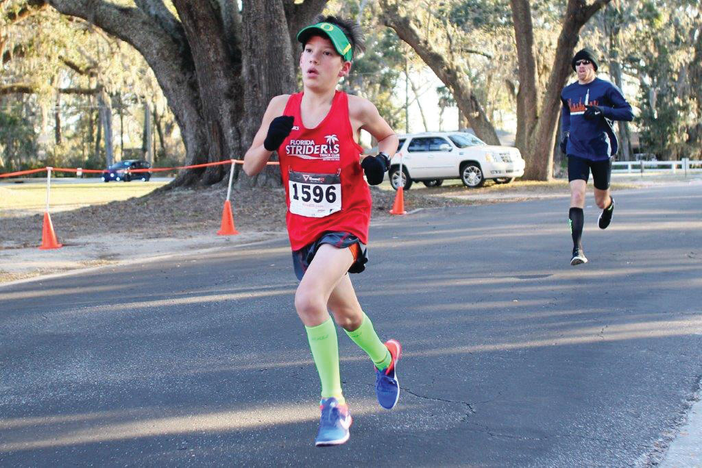 John Keester, 11, powers to finish for first place in age group in 19:10 and 14th overall.