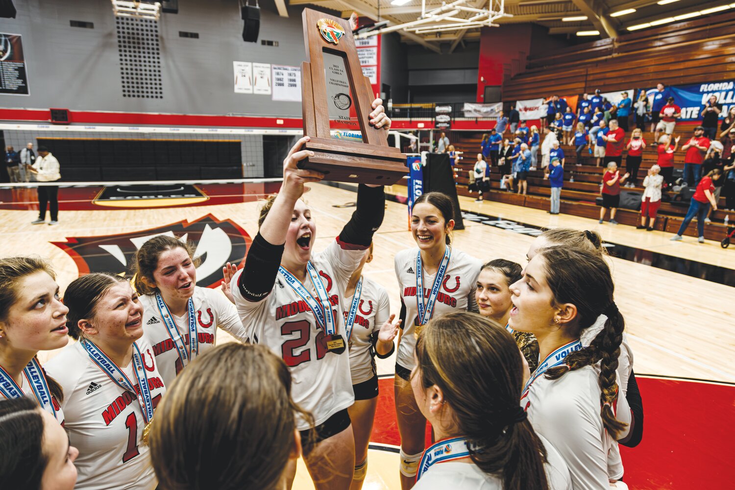 Middleburg High setter Olivia Callipo holds up the Class 5A championship trophy after her Broncos beat Barron Collieer 3-0 in Winter Haven to secure the first-ever volleyball state title.