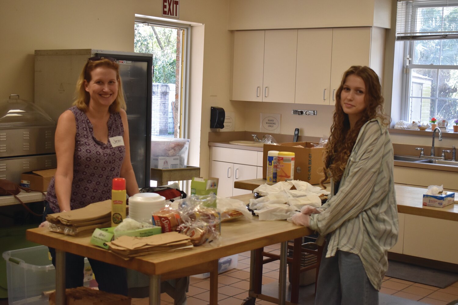 From left, volunteers Christiane Loring, Alyssa Torres, Jenn, and Camille Knight prepared meals for anyone who needed them last Saturday at the Orange Park Senior Center. After delivering meals in a drive-through at First Baptist Church of Orange Park since the onset of the COVID-19 pandemic, The Kitchen of Clay County not only found a new home, but it finally could invite residents to sit down and be served.