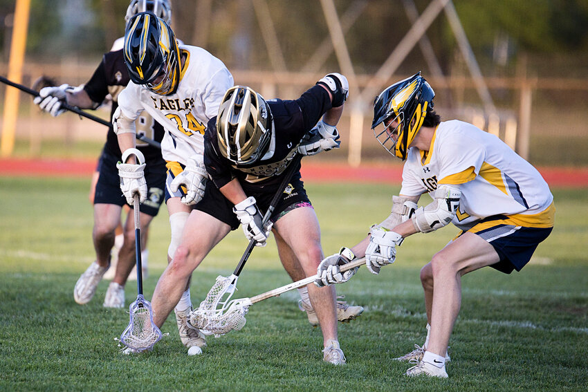 Barrington's Nick Spaight (left) and Ben Parylak (right), shown digging the ball out from under a North Kingstown opponent during a lacrosse game last year, scored three goals in the Eagles' recent win over Cumberland.