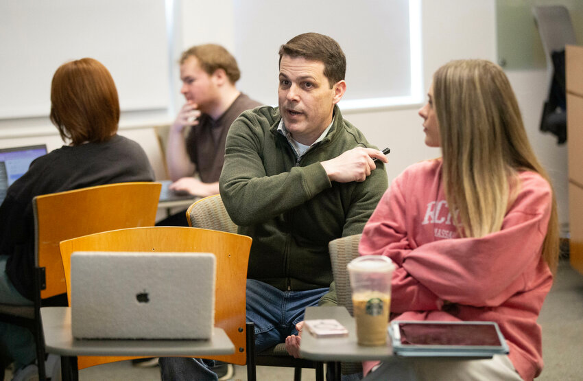 Professor Bernardo Motta sits with his students, engaging in one-on-one conversations about environmental issues. 