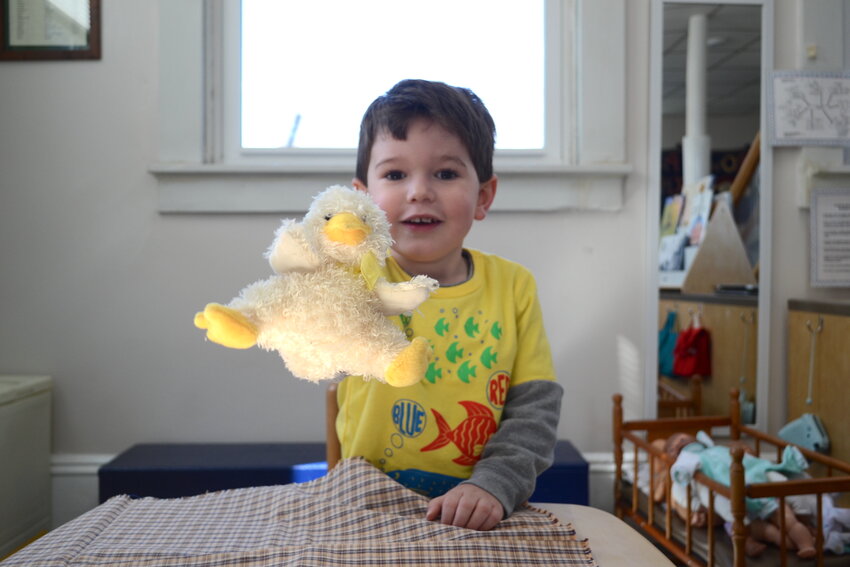 A Brown Play School student holds up a toy chick while in the homemaking portion of the school. He was particularly excited about the eggs that were contained within an incubator that day, awaiting their time to hatch.