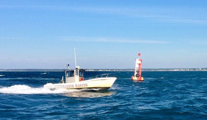 The Westport Harbormaster's boat heads out past the old lighted bell buoy 1 in this Westport Shorelines file photo. The red and white can was replaced with a green can about nine years ago, and that can is now itself being eyed for removal.