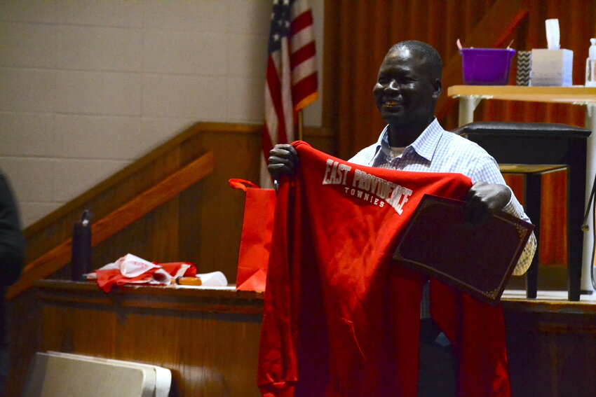 Panther Alier holds up an East Providence Townies sweatshirt gifted to him prior to speaking at Riverside Middle School. He first came to East Providence to share his story in 2004, after fleeing his homeland of South Sudan in 1987 and ultimately coming to America in 2001.