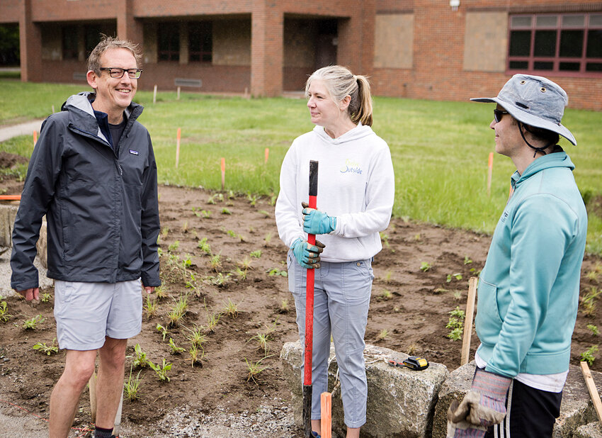 Shannon Rozea, landscape artist and founding director of Thrive Outside, speaks with volunteers while helping to fill the Kickemuit Middle School outdoor learning zone with greenery.