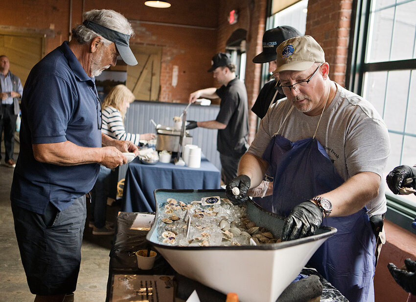 RI Shellfish Association President Mike McGiveney (left) and member Scott Travers (right) shuck clams during the "Quahog Week" event held at The Guild Restaurant on Water Street in Warren Wednesday, May 14.