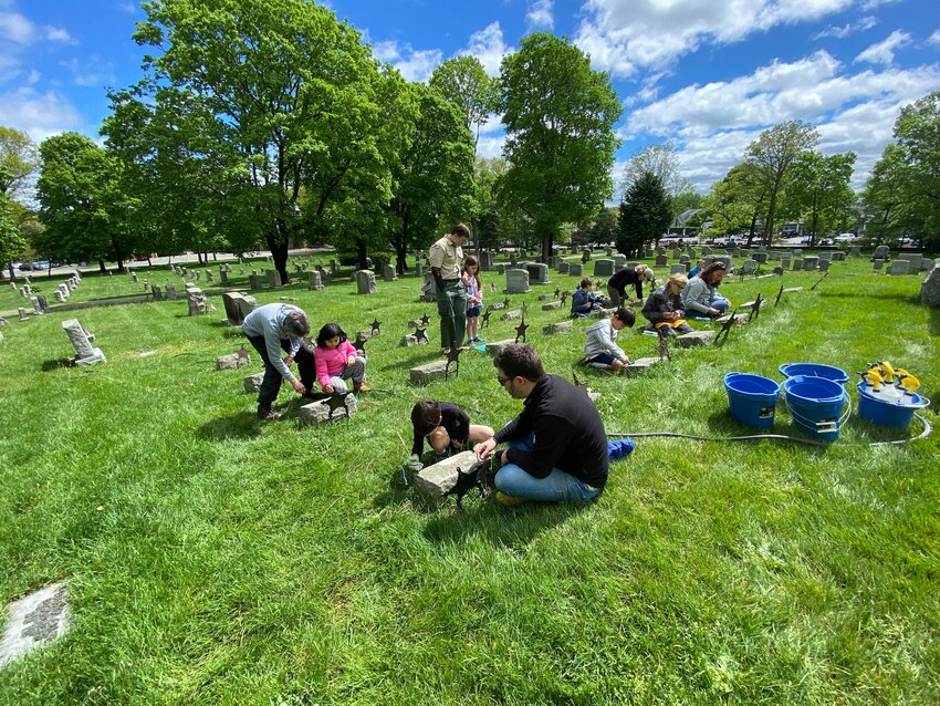 Members of Cub Scout Pack 1 Barrington and their parents clean Civil War monuments and markers inside the Prince’s Hill Cemetery recently.