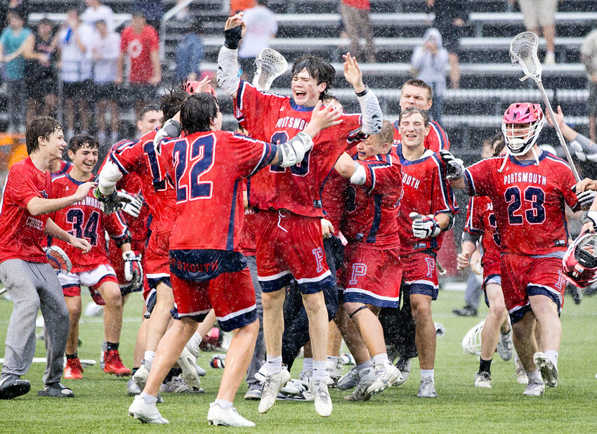 Chase Pascoe (center) and other Patriots race out onto the rain-soaked field at Brown University to celebrate their 15-6 win over East Greenwich to capture the Division II boys’ lacrosse title on Saturday. Pascoe led the offense with five goals.