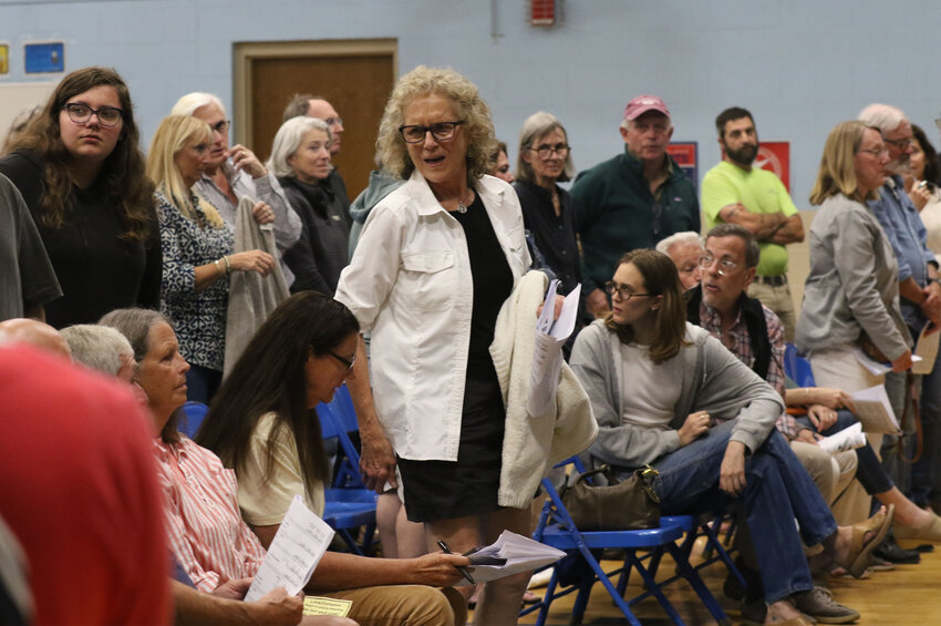 Residents stand to vote, to approve a vote on amendments 1-64 as a block. The community later passed the block of amendments with a verbal vote, approving a 12 percent tax levy hike — three times what state law normally allows.
