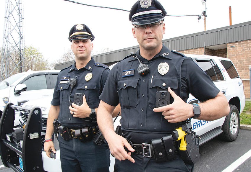 Bristol Police Sgt. Brian Morse (left) and patrolman Sean Gonsalves demonstrate the use of Axon body cameras, which will now be utilized by all Bristol police officers thanks to a state and federal grant.