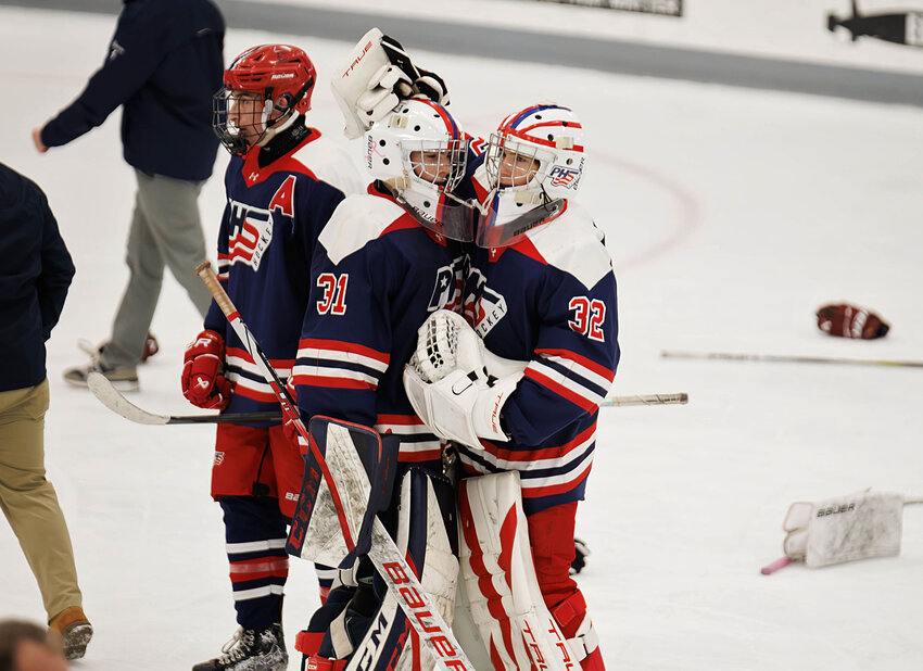 Portsmouth goalies Jonathan Cabral and Ben Humm share a hug after their team lost 4-3 to East Greenwich-Toll Gate in sudden-death overtime.