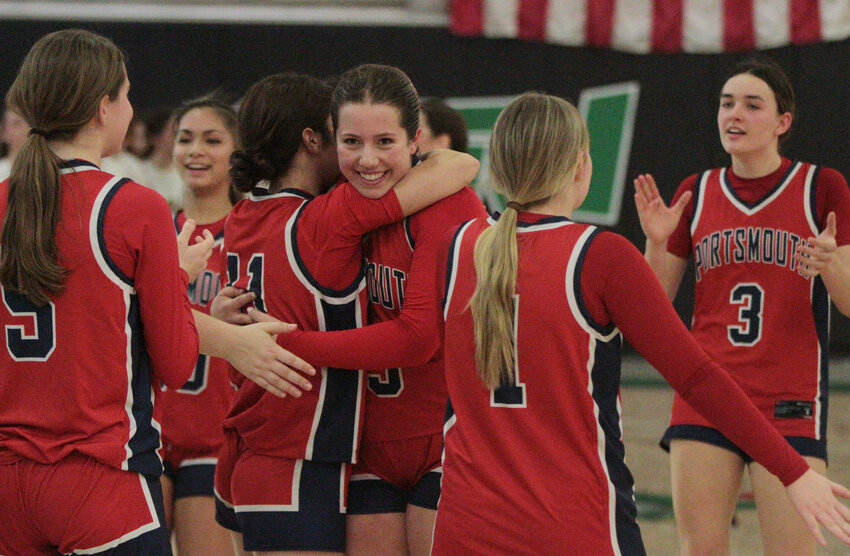 Stella Orr (middle) receives a hug as teammates celebrate their “elite eight” win over Barrington at CCRI. Orr finished the game with 17 points, 10 rebounds, and two blocked shots.