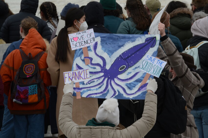 This sign references the “Squid Squad”, a group of scientists from the NOAA Fisheries division based out of Rhode Island who track squid populations and movements. The team lost its funding due to cuts made by the Trump Administration.