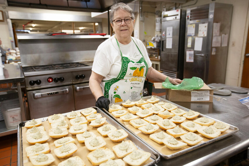 Margie Sousa 18-year volunteer, preps garlic butter and bread before warming it in the oven. 