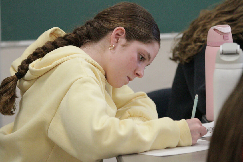 Isla Bartlett writes an essay during a writing exercise with author Ethan Gilsdorf.