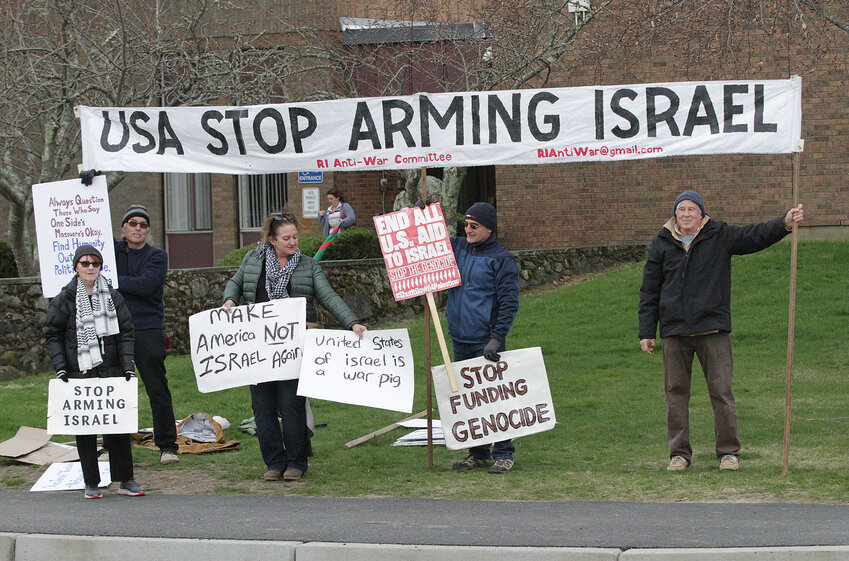 Protestors representing the R.I. Anti-War Committee line the front of the sidewalk in front of Portsmouth Middle School.