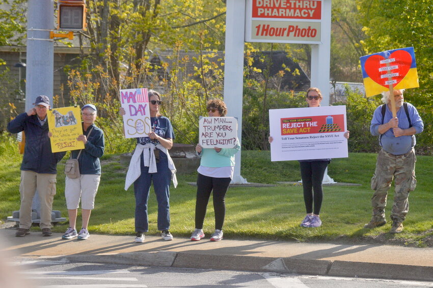 Protesters display signs at passing motorists during rush hour on Thursday, May 1, in Portsmouth.