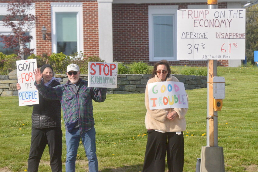 Protesters display signs at passing motorists during rush hour on Thursday, May 1, in Portsmouth.