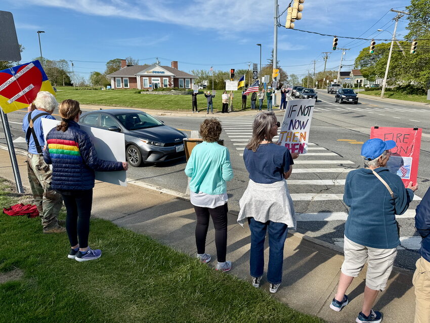 Protesters display signs at passing motorists during rush hour on Thursday, May 1, in Portsmouth.