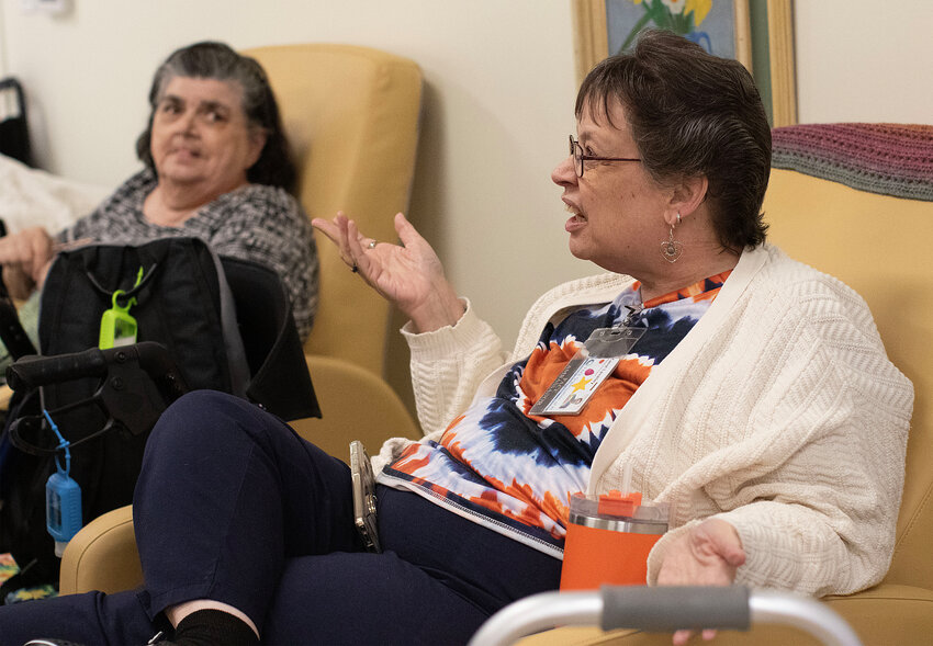 To the right, Carol LaValley explains how the services at PACE have resulted in huge health benefits for her in just two years. In the background, Marie Ward listens. Ward has been using PACE services for 11 years.