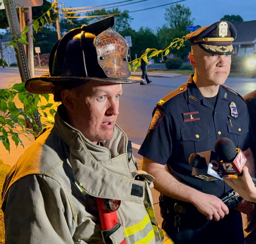 Assistant Fire Chief Howard Tighe (left) and Police Chief Brian Peters address members of the media in front of St. Anthony’s Church, across from the Portsmouth Portuguese-American Citizens Club Saturday night.