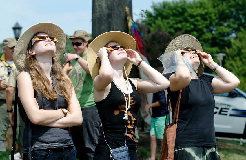 People use special eclipse-viewing glasses during a special event in 2017 outside the Barrington Town Hall.