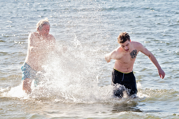 Michael Burke (right) cringes as his uncle, Bob Burke, splashes him with water during a polar plunge at Barrington Beach.