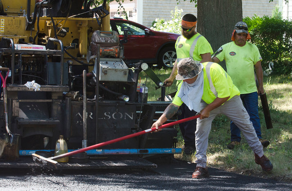 Workers spread asphalt across Beaver Road in Barrington in 2018. The same contractor, Pawtucket Hot Mix Asphalt, was awarded a more recent bid also.