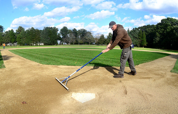 Barrington DPW worker Moses Massa rakes the home plate area of at one of the Haines Park baseball fields. The town is considering field improvements at Haines.