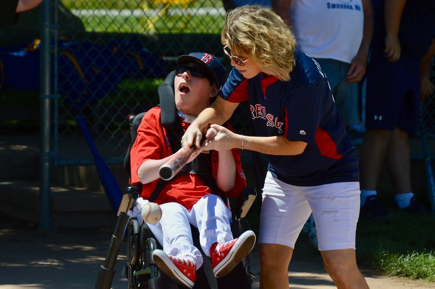 Austin Wildnauer, 17, gets some help from his mom, Pam, as he hits off a tee during the 13th annual Challenger Jamboree at Glen Park on Sunday.