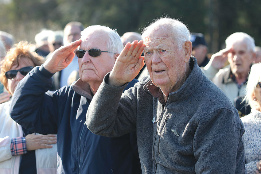 World War II veterans Clifford Brightman (left), an Army medical corps vet, and John Miller, an Army and Air Force vet, salute the American Flag during the singing of the National Anthem during the Westport Veterans Day ceremony at Beech Grove Cemetery.