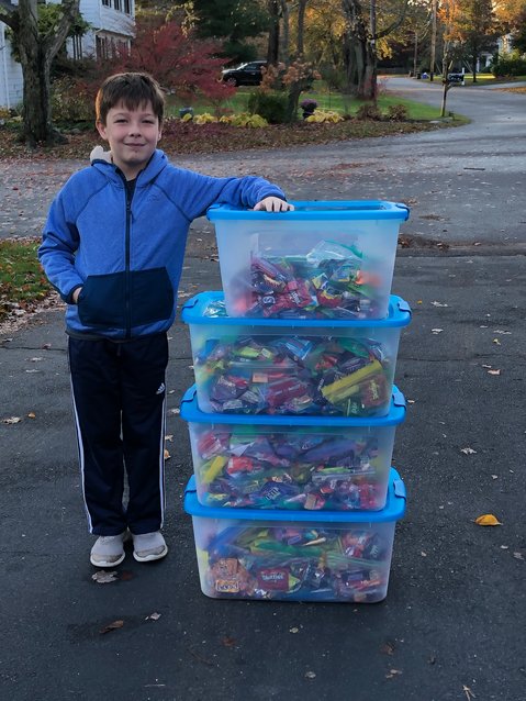 Daniel Shea stands beside bins of the Halloween candy he collected and then later donated to Amos House.