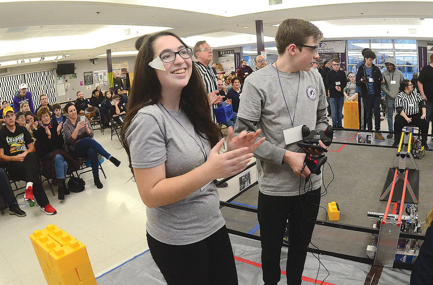 Rebecca Oliver (left) and Simon Thibault celebrate and gather their gear after their team, the TaterBots, won a round that jettisoned the team into the finals at the First Tech Challenge robotics competition at the high school on Saturday.