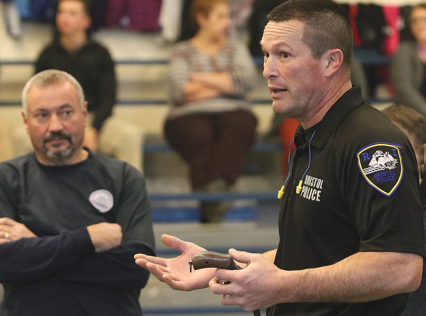 Colt Andrews employees listen as Bristol patrolman John Mlynek delivers instruction during an active shooter training at Colt Andrews School.