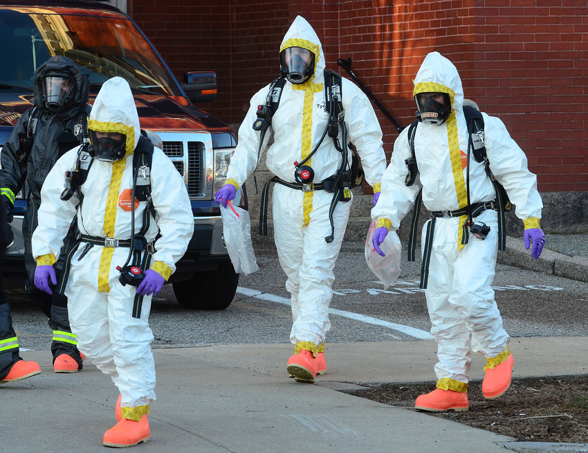 An East Providence special hazards team emerges from the Bristol Warren school administration building with evidence late Wednesday afternoon.