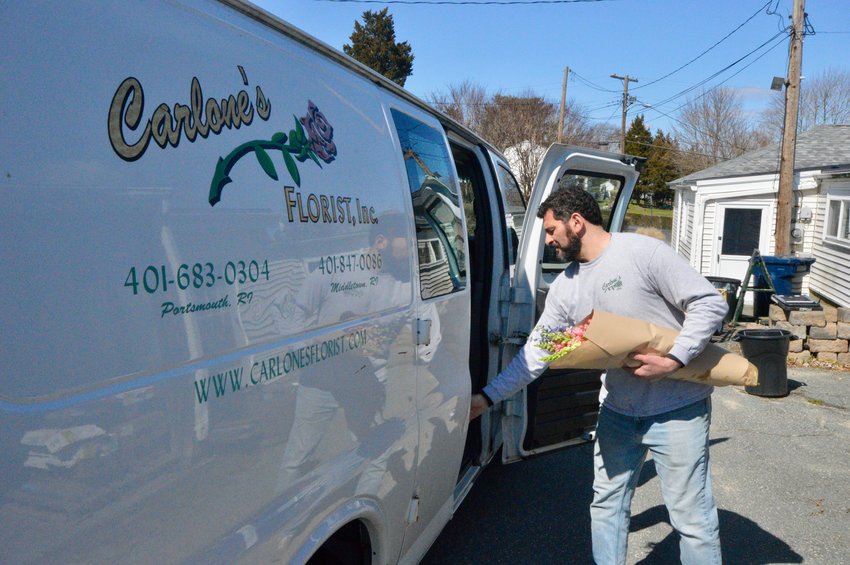 Brian Weeks of Carlone&rsquo;s Florist brings some flowers out to the delivery van Tuesday afternoon. Deemed a &ldquo;non-critical&rdquo; business by the State of Rhode Island, the flower shop was ordered to close its doors through at least April 13 to contain the spread of the coronavirus. The business is still filling delivery orders, however.