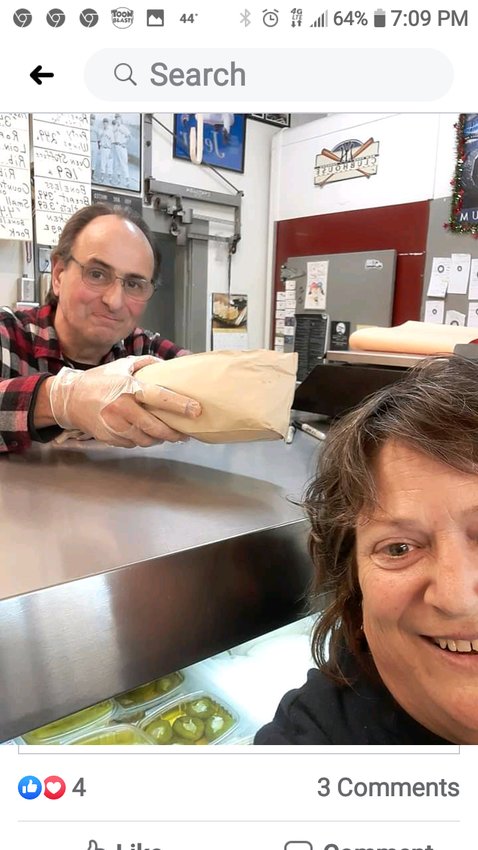Victor Goglia hands the last of Goglia&rsquo;s Market&rsquo;s legendary grinders to Sue Rohrman of State Street on Thursday, April 2.