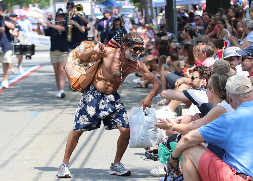 Joe Estrella Jr. of Fall River offers an elbow (long before Covid-19 eradicated handshakes) to a parade watcher along Hope Street during the 2019 Bristol Fourth of July parade.