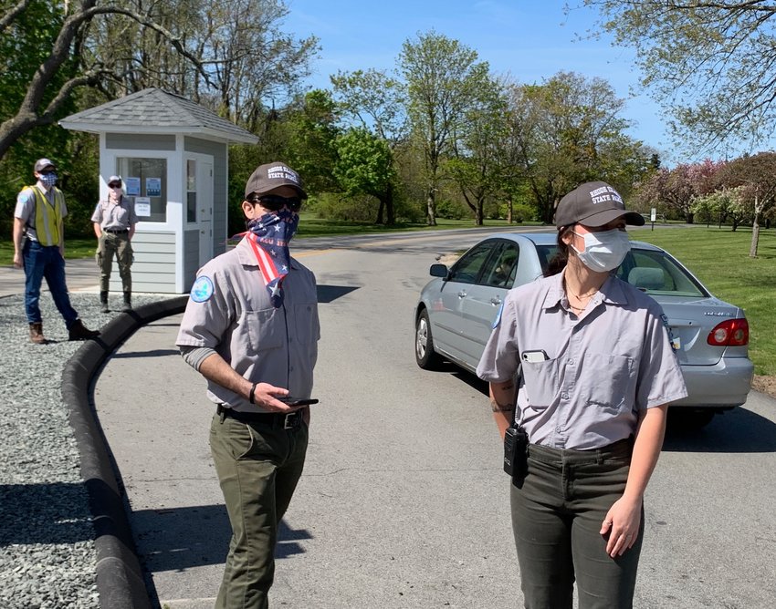 DEM park rangers Matt Cordeiro and Jillian Bannon check in cars at the Colt Park entrance Thursday morning